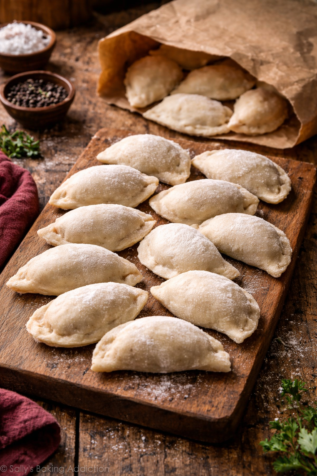 Tiefkühl-Pierogi auf Holzbrett mit Kraftpapier-Tüte